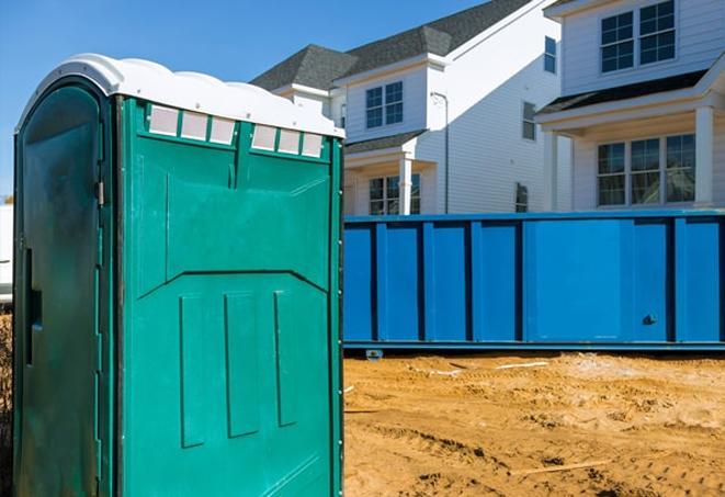 a row of portable toilets on a bustling construction site